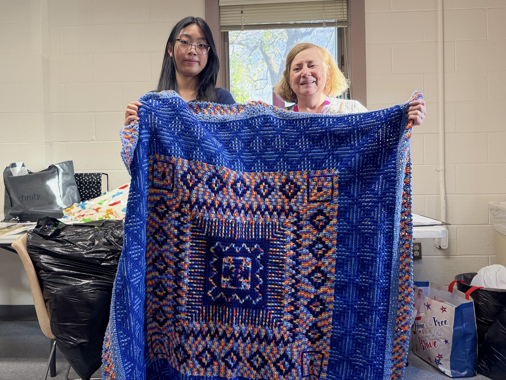 Ciara Feng presenting a handmade crochet blanket to MCAFCE